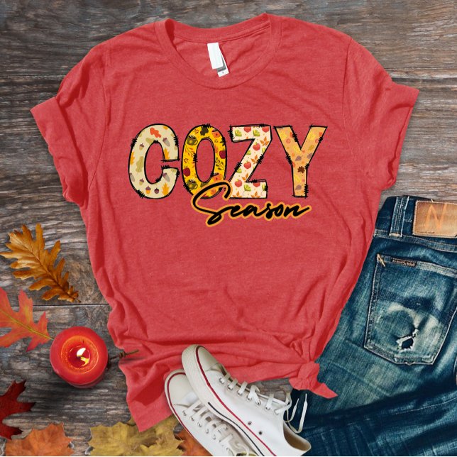 T-shirt för mysigt säsong (Cozy season doodle letters t-shirt design with floral autumn patterns)