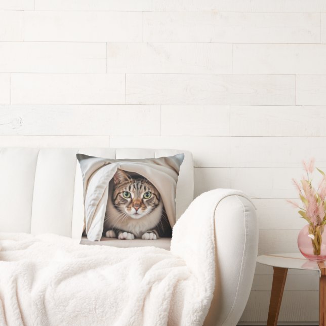 Tabby katt Gömmer under en vevett Kudde (Soffa)