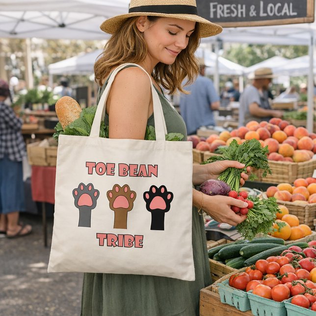 Tåböle-stammen Söta Kattfötter Tygkasse (A tote bag with three cat paws and the words toe bean tribe in pink with a gray outline.)