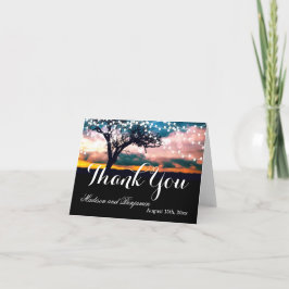 Tackkort med strängljus och träd vid solnedgång fö