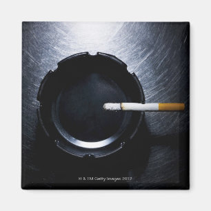 Tänt cigarett och askfat på rostfritt stål magnet