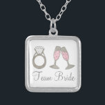 Team Bride Bröllop Champagne Bridesmaid Necklace Silverpläterat Halsband<br><div class="desc">Necklace har en originalmarkör som illustrerar ett glas bubbelfärgad rosa champagne och en diamant bröllop ring,  med TEAM BRIDE i ett roligt. En underbar brud/brudens sida-gåva!</div>