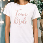 Team Bride Bröllop Personlig Dusty Rosa White T Shirt<br><div class="desc">Fira din bridtrupp med den här personligen bröllop t-shirt! Ordens "Team Bride" skrivs i ett trendig-skriptteckensnitt,  och under kan du lägga till ett eget namn,  bröllop-datum,  plats eller annan text. En underbar gåva till en bachelorettfest,  möhippa eller firande helg! Färg: dammig rosa och vit.</div>