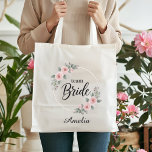 Team Bride Custom Elegant Pink Floral Gold Wedding Tygkasse<br><div class="desc">Add a touch of floral elegance to your wedding celebration! This stunning Team Bride tote bag features a beautiful double gold hoop wreath adorned with romantic pink watercolor roses and soft green foliage. It's the ideal bridesmaid gift bag, perfect for holding all the essentials for a bachelorette weekend, bridal shower,...</div>