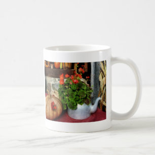 Tekanna som fylls med pelargoner kaffemugg