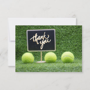 Tennis boll är på grönt gräs med chalkboard tack kort