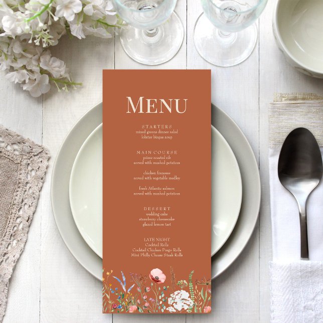 Terrakotta Vildblommeäng Bröllopsmeny Kort (Terracotta Wildflower Meadow Wedding Menu Card on a boho white wedding dinner table.)