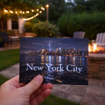 The Allure of New York City  Vykort<br><div class="desc">Capture the magic of the city that never sleeps with this stunning New York City skyline postcard. Featuring the illuminated Manhattan skyline glowing against the night sky and reflecting across the water, this striking cityscape showcases the energy, beauty, and iconic architecture that make NYC unforgettable. Perfect for travelers, city lovers,...</div>