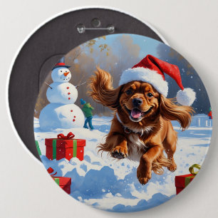 Tibetansk Spaniel springer i snö med julhatt Knapp