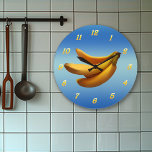 Tid för bananer stor klocka<br><div class="desc">Bananbunt mot blå bakgrund med gult nummer.</div>