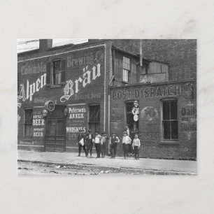 Tidningsförsäljare utanför en saloon, 1910 vykort
