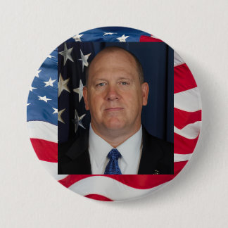 Tom Homan Button with flag waving behind Knapp