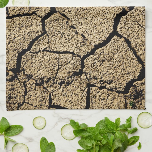 Torr mark med krackad jord under torka kökshandduk (Vikta)