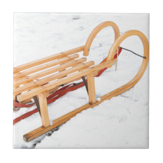 Träbarnsled i vintersnö kakelplatta