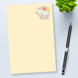 Trädgårds- bevattna kan med blommor på gult post-it block