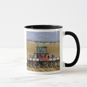 Traktor som drar en majssämaskin. mugg