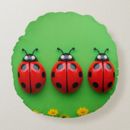 Tre färgglada nyckelpigor på grön bakgrund rund kudde