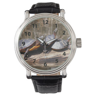 Tre sköldpaddor på en logg armbandsur