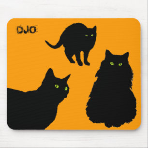 Tre svarta katter och orange musmatta