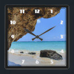 Tropiska Beach Kusten med Stora Sten Fyrkantig Klocka<br><div class="desc">En klocka med ett naturfotografi. Vackert blått hav med sandstrand. Ett stort brunt sten ger lite skugga från det ljusa blå himmel.</div>