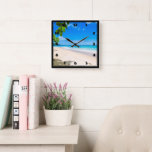 Tropiska persikor i sol och Surfa Fyrkantig Klocka<br><div class="desc">En klocka med ett vackert foto. En vit sandstrand med azurblått vatten. Lättare bild med en solig himlar och mjuk skumbildande surfa med söta tropiska löv som ramar in bilden.</div>