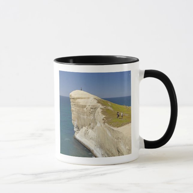 Turister på klipptopp vid Tunnel Beach Mugg (Höger)
