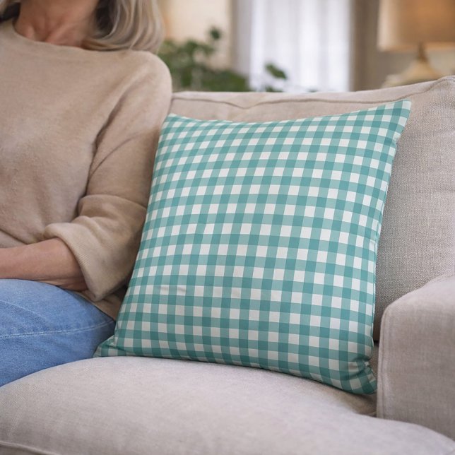 Turkos och vit gingham-mönster kudde (A throw pillow with a teal and white gingham pattern)