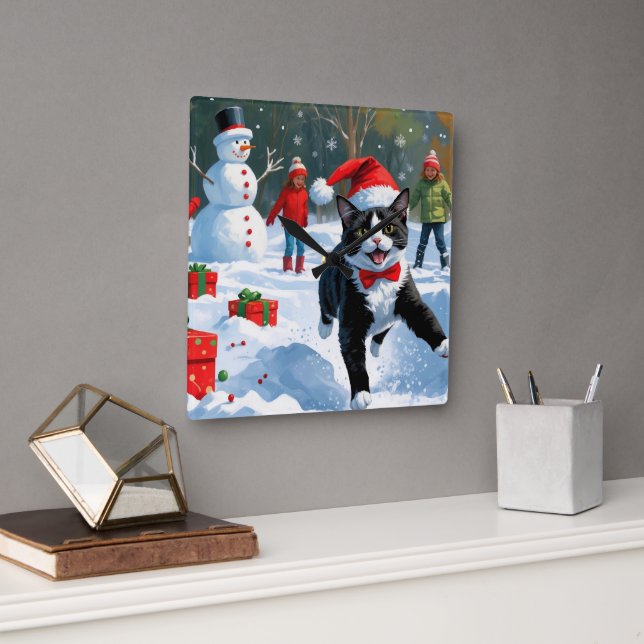 Tuxedokatt springer i snö med julhatt fyrkantig klocka (Kontor)