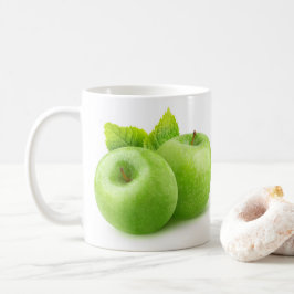 Två äpplen av grönt kaffemugg