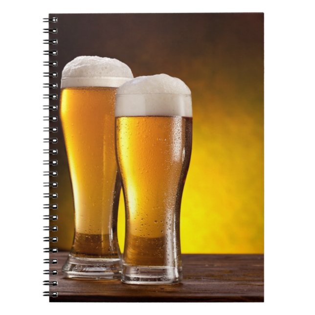 Två glas öl på en bord av trä anteckningsbok med spiral (Framsidan)