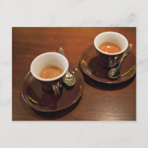 två kopp färskbryggat espressokaffe på en vykort