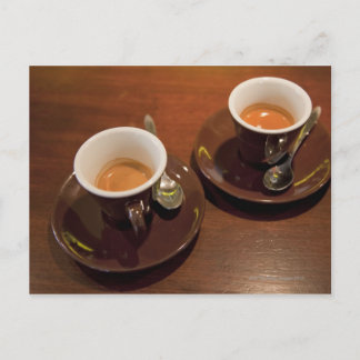 två kopp färskbryggat espressokaffe på en vykort