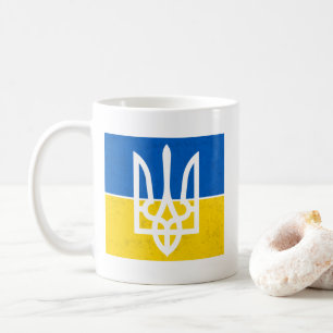 Ukrainas flagga och jackande av arm kaffemugg