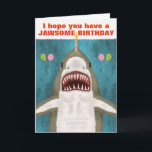 Underbar White Shark Funny Jawsome Birthday Pun Hu Kort<br><div class="desc">Den Underbara vitaktigen på det här roliga hälsningskortet är så vänlig. Ser du? Det ler och hoppas att du har en julfödelsedag. Den har till och med tagit ballonger och balanserar ett ljus på näsan. Utformningen omfattar en handdragen haj på blått/havs-grönt med silhuetter från att fly fisk. Använda den lättlästa...</div>