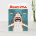 Underbar White Shark Funny Jawsome Birthday Pun Hu Kort<br><div class="desc">Den Underbara vitaktigen på det här roliga hälsningskortet är så vänlig. Ser du? Det ler och hoppas att du har en julfödelsedag. Den har till och med tagit ballonger och balanserar ett ljus på näsan. Utformningen omfattar en handdragen haj på blått/havs-grönt med silhuetter från att fly fisk. Använda den lättlästa...</div>