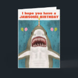 Underbar White Shark Funny Jawsome Birthday Pun Hu Kort<br><div class="desc">Den Underbara vitaktigen på det här roliga hälsningskortet är så vänlig. Ser du? Det ler och hoppas att du har en julfödelsedag. Den har till och med tagit ballonger och balanserar ett ljus på näsan. Utformningen omfattar en handdragen haj på blått/havs-grönt med silhuetter från att fly fisk. Använda den lättlästa...</div>