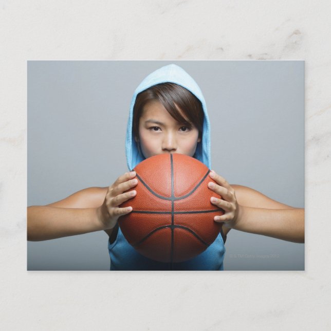 Ung kvinna med basket tittar i kamera vykort (Framsida)