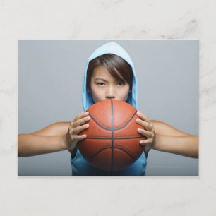 Ung kvinna med basket tittar i kamera vykort