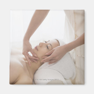 Ung kvinna som har ansikts- massage magnet