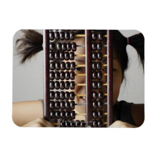 Ung kvinna som plirar till och med abacus.en magnet