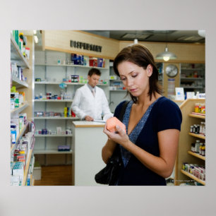 Ung kvinna tittar medicin i apotek, poster