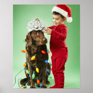 Ungpojke som slår in ljus runt en hund poster