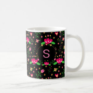 Uppslukande blommönster på svart monogram kaffemugg
