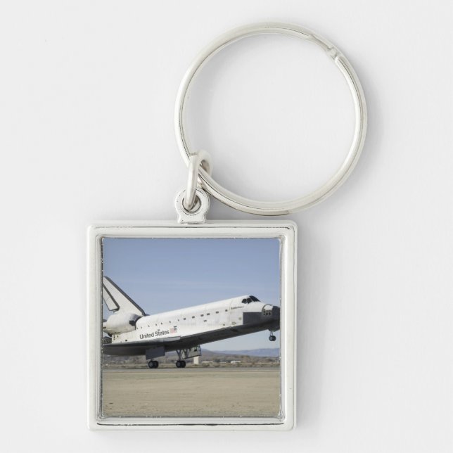 Utrymmeskretsens huvudlandningsställ fyrkantig silverfärgad nyckelring (Framsidan)