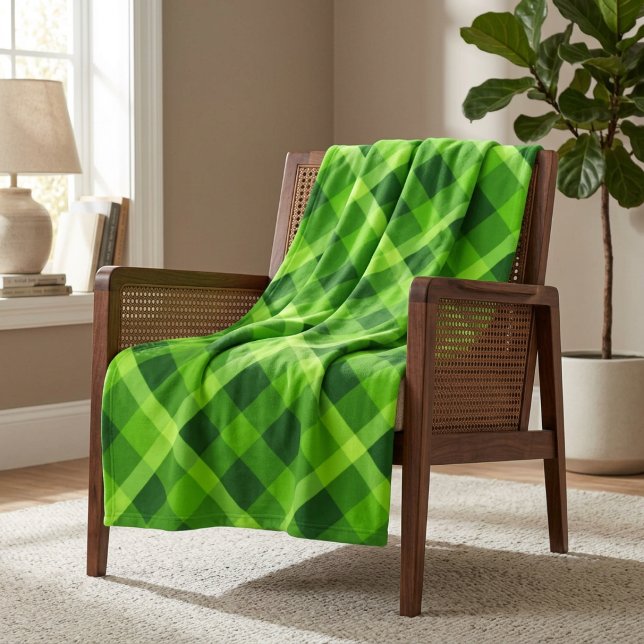 Vacker grön rutmönstrad filt i medium fleece (Beautiful Tree Green Plaid Medium Fleece Blanket draped over a chair in a home.)