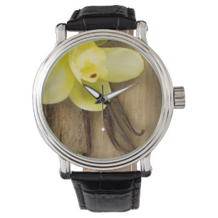 Vaniljpoder och blomma över träbakgrund armbandsur