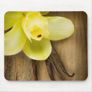 Vaniljpoder och blomma över träbakgrund musmatta