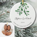 Vår första julklapp har gett ett felfritt foto julgransprydnad keramik<br><div class="desc">Fira din första jul som ett förlovat par med den här snyggten fotokeramiskt prydnadsämne. Den är dekorerad med vattenfärgsmistletoe och elegantens skripttypografi. Anpassade med namn,  datum och foto. Använda Verktyg i Design om du vill ändra texten storlekt,  stil eller färg. Ursprunglig vattenfärg © Michele Davies.</div>