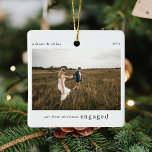 Vår första julklapp som engagerar oss för fotobeva julgransprydnad keramik<br><div class="desc">En snyggt fotot av julgran-prydnadsämne med klassisk typografi "Vår första julklapp" i svart på en ren, enkel, vit bakgrund. Foto, text, namn/s och år kan enkelt anpassas för att göra detta unika och personliga för dig. En enkel, minimalistisk och contemporary julklapp som tillkännager din förlovning för dina nära och kära!...</div>