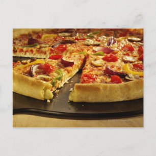 Vegetabilisk pizza skuren på svart panna på trä vykort